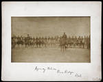 Photograph of over two dozen men on horseback.